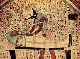 Египетский бог смерти Анубис склонился над мумией